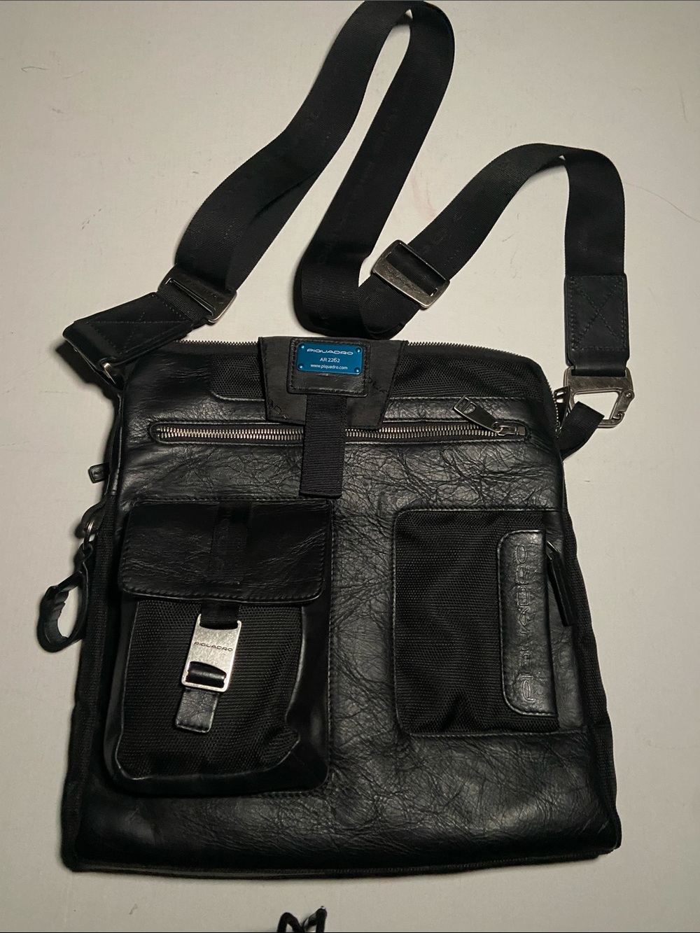 Piquadro messenger bag features premium black leather and nylon composition.